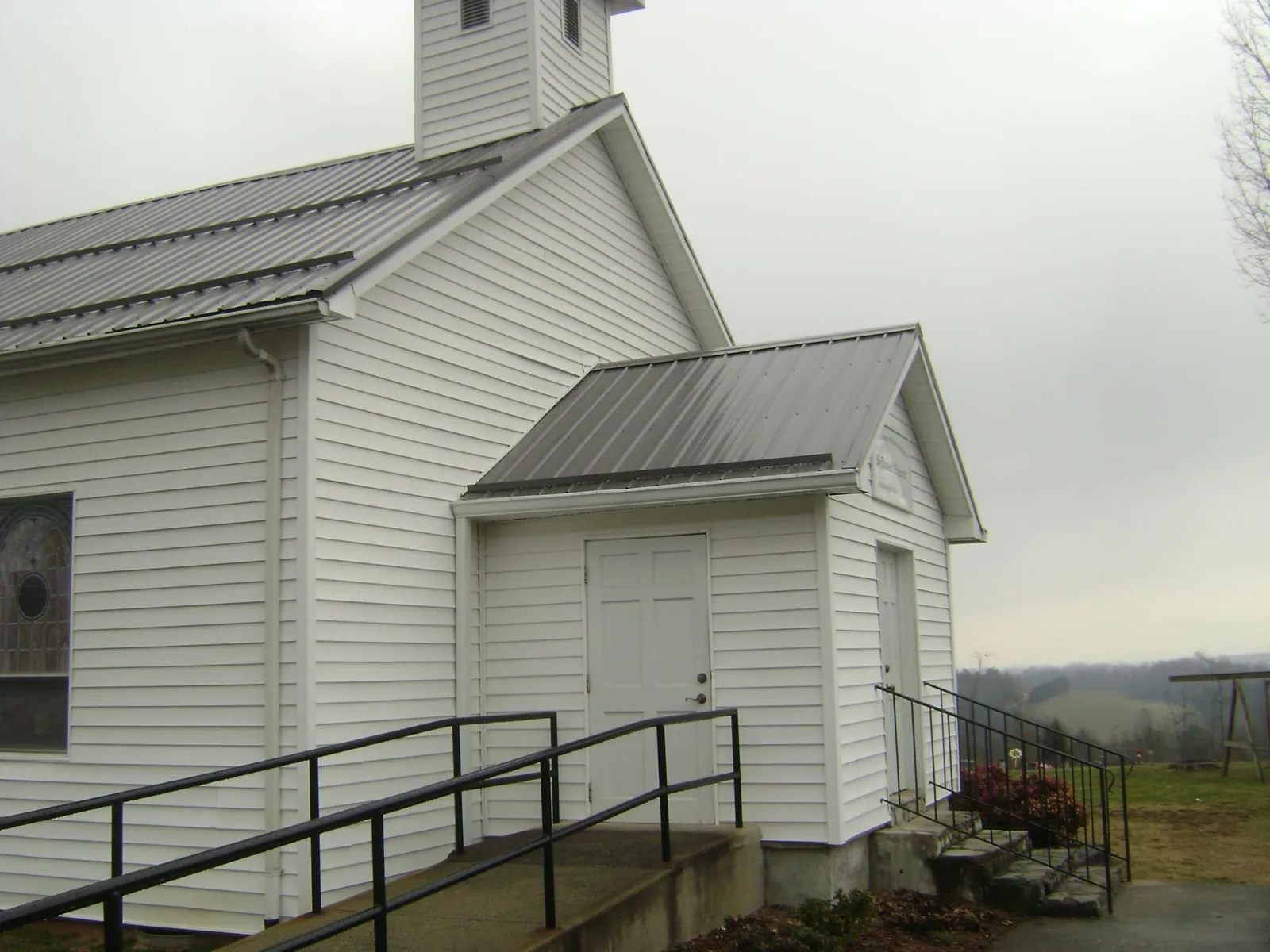 Gray metal roof on a white clapboard church with a steeple in Hobart